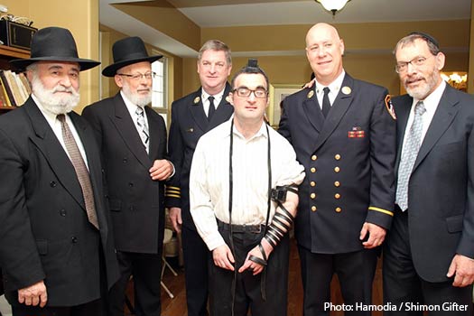 R-L: Mr. Shmuel Kahn, executive director of HASC, Chief Michael Gala Jr. of the FDNY; James Leonard, deputy assistant to Chief Gala, Mr. Shalom Hurwitz, the HASC resident whose Tefillin were found, Mr. Yaakov Grunfeld, who returned the Tefillin, and Mr. Shmuel Hurwitz, Shalom’s father. (Photo Shimon Gifter for Hamodia)