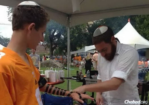 A University of Tennessee student puts on tefillin before the game.
