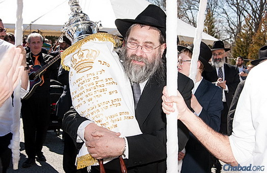 Rabbi Chaim Meir Lieberman, Rashi Minkowicz’s father, holds the new Torah scroll in honor of his daughter, who passed away last year at the age of 37, as part of a communal Torah procession. (Photos: David Adler Photography and Deb Weidinger Art-Photograph-Design)
