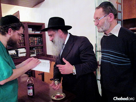 The mohel, Mordechai Tzvi Salamon, left, with the rabbi and Pasternak.