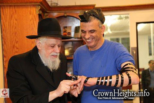Rabbi Binyomin Klein puts on Tefillin with Mr. Moshe Kachlon, Israels then minister of social welfare.