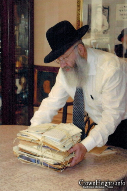 Rabbi Shalom Ber Schapiro, Son-in-law of Rabbi Mindel, with a bundle of files from his archives.