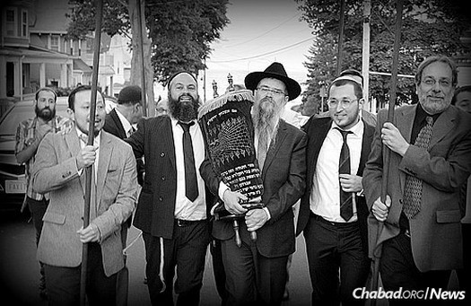 Walking the Torah in a procession from Ahabat Sholom in Lynn, Mass., to Chabad of the North Shore, where the rededication ceremony took place.