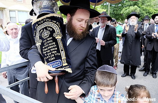 Rabbi Baruch Hertz, rabbi of the Chabad community in Chicago, here with two of his children, noted that the event was the result of an effort spanning the entire community. (Photo: Deja Views)