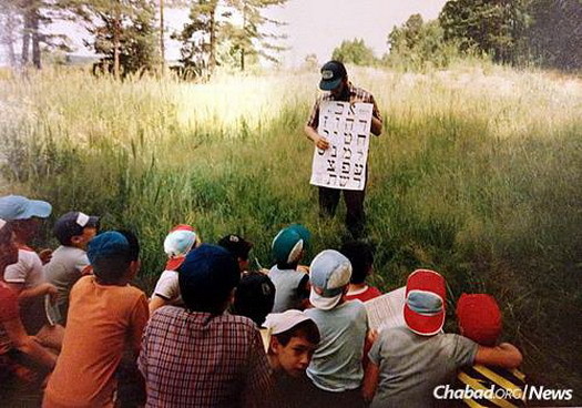 Despite wide language differences, the first batches of American yeshivah-students-turned-counselors at Camp Gan Israel managed to find a way to communicate with their young Russian-Jewish charges. Here, a counselor introduces his campers to the alef-bet in the summer of 1990.