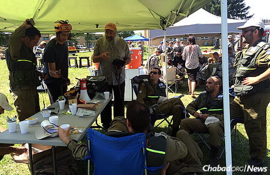 Tefillin in hand, the rabbi chats with the visiting Israelis in the U.S. Midwest.