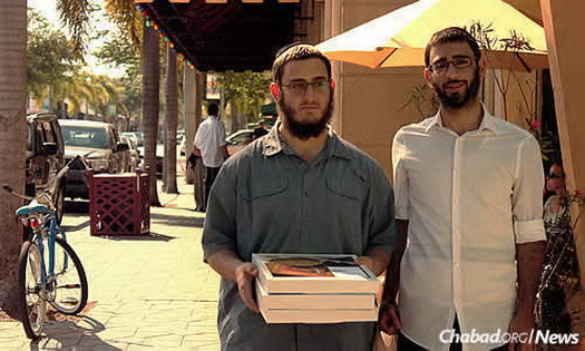 Lew and Rosenthal hand out boxes of shmurah matzah for Passover on the streets of Lake Worth.