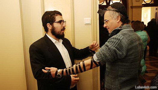 Mendel Moskovitz assists someone in putting on Tefillin at an event in Kharkiv, Ukraine.
