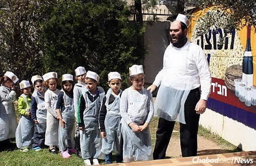 Rabbi Raskin instructs children at a “Model Matzah Bakery” workshop prior to Passover.