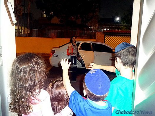 Dvorah Lea Raichman, co-director of Chabad-Lubavitch of Manaus, Brazil, with her husband, Rabbi Arieh Raichman, waves goodbye to her children as she makes the long commute to a mikvah. The couple has begun a campaign to construct a local kosher mikvah.