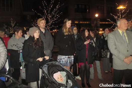 Young families, like those here at this year's public menorah lighting, are drawn to the many new Jewish programs in town for grownups and kids alike.