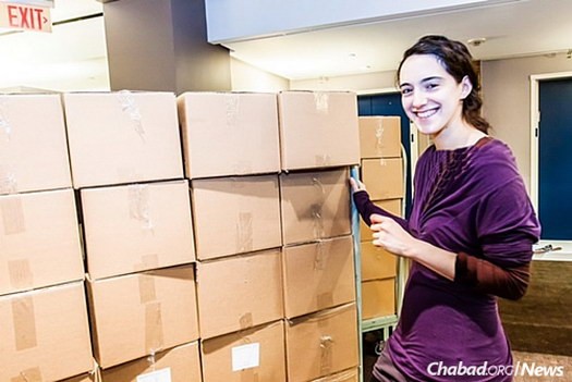 Nadia Talel helps stack the packed boxes, all ready to be delivered to homes of the needy.