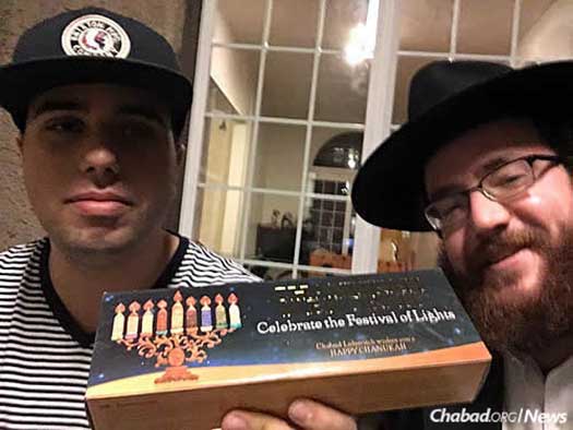 Student Jonathan Benaroch gets a menorah from the rabbi.