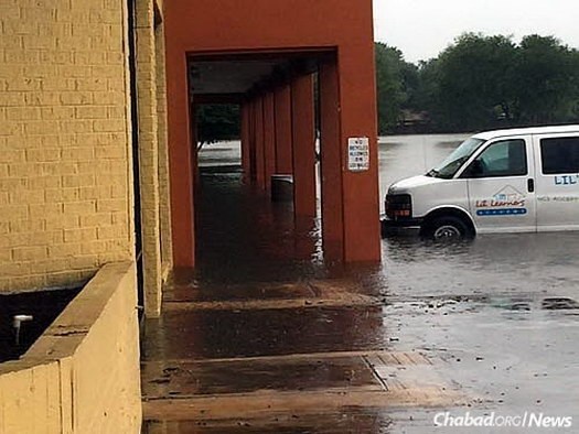 Water pools in front of a local kosher pizza shop.