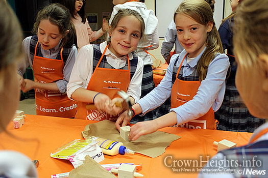 Kids make Chanukah dreidels from wood at a local Home Depot holiday workshop.
