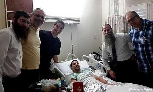 Visiting Yossi Morad, who fell during a skydive in Florida, are, from left: Rabbi Motty Rosenfeld of Chabad of Vero Beach, Fla.; Ariel Shapira, a member of Chabad of the Space & Treasure Coasts in Satellite Beach, Fla.; Tamir Galili, a member of Chabad of South Orlando, Fla.; Rabbi Zvi Konikov, director of Chabad of the Space & Treasure Coasts; and Shimshon Galili, a member of Chabad of South Orlando.