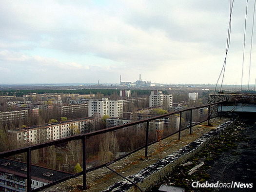 A view of the evacuated town of Pripyat, which was built to house workers at Chernobyl. The remains of the reactor can be seen in the distance.