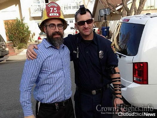 Rabbi Choni Marozov, co-director of Chabad of S. Clarita Valley, wraps tefillin with a Jewish firefighter.