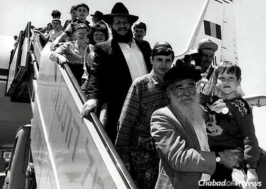Jewish children affected by the Chernobyl reactor disembark from the Tarom Romanian airplane in Tel Aviv. Holding a child in the front is Shlomo Maidanchik, a Chabad activist in Israel who served for many years as mayor of Kfar Chabad. Behind him is Aronov.